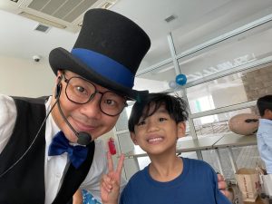singapore kids party magician derek posing with a guest after show